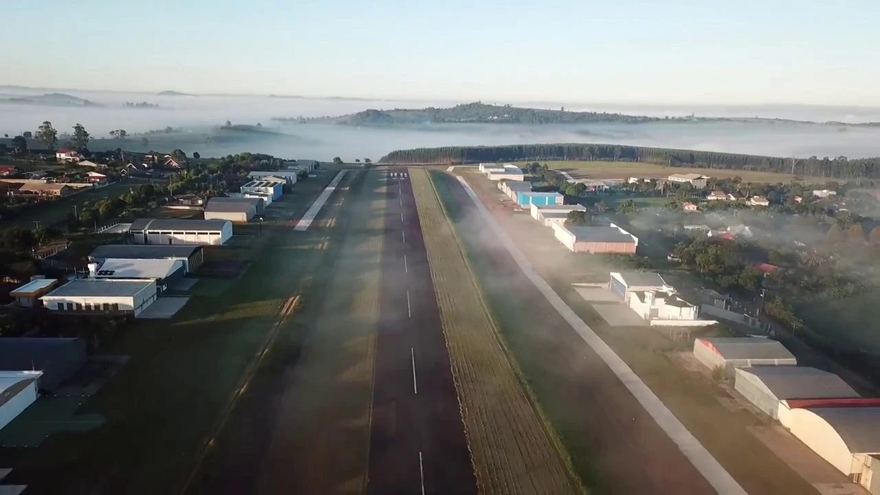 Vista aérea da pista do Vale Eldorado ao amanhecer, com neblina no vale